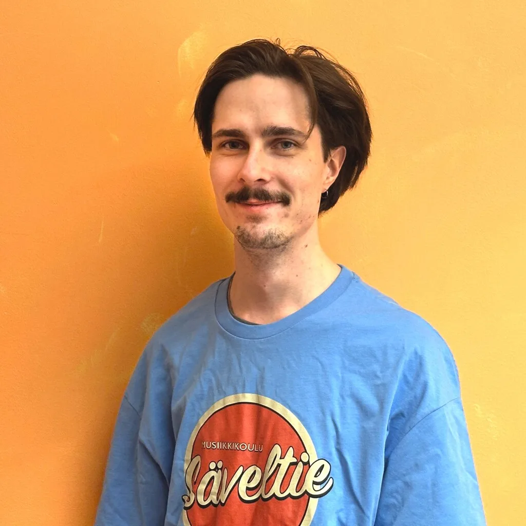 Taneli Kiiskinen Kuvassa Musiikkikoulu Säveltien opettaja Taneli hymyilee. Musiikkikoulu Säveltie tarjoaa Helsingin parhaat rumputunnit lapsille ja aikuisille. Rumputunnit Helsinki – Rumputunnit Helsingissä.